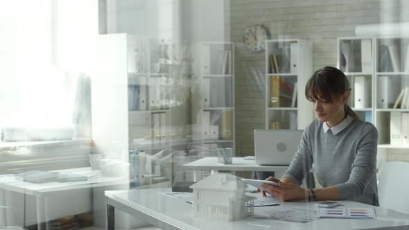 Female Architect Using Digital Tablet at Office Desk