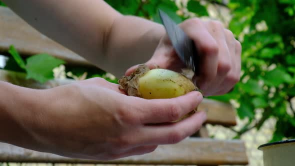 Peeling Young Potatoes with a Knife in Nature