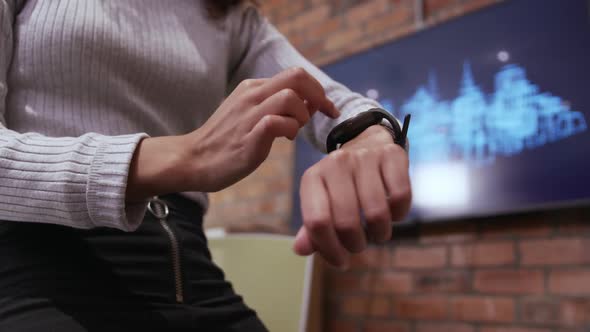 Mid section of creative businesswoman using smartwatch