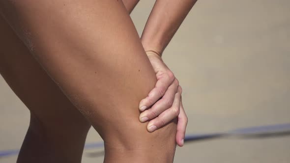 Detail of women playing pro beach volleyball.