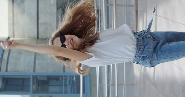 Happy Little Girl in Stylish Look and Glasses Dancing and Having Fun at Camera