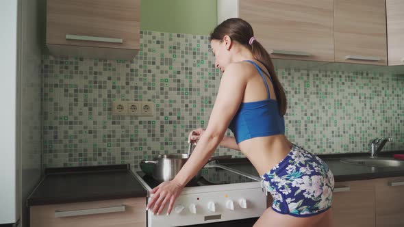 Sexy beautiful Girl short shorts and topic preparing food in kitchen and dancing