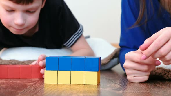  Mom and Son's Hands Building a Boxes From Colored Cubes and Blocks