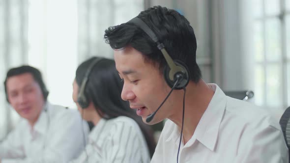 A Man Call Centre Agents Speaking To Customers While His Colleagues Are Talking With Each Other