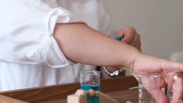 Closeup of a Pipette with Oil and a Glass Bottle