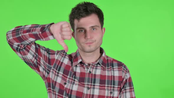Portrait of Thumbs Down Gesture By Young Man Green Chroma Screen