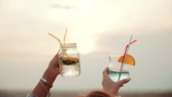 Girls Hands Raise Glasses with Colored and Delicious Summer Urban Cocktails