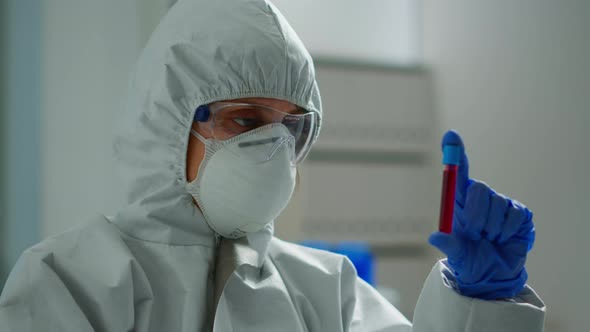 Scientist in Coverall Doing Research Analysing Liquid in Tube