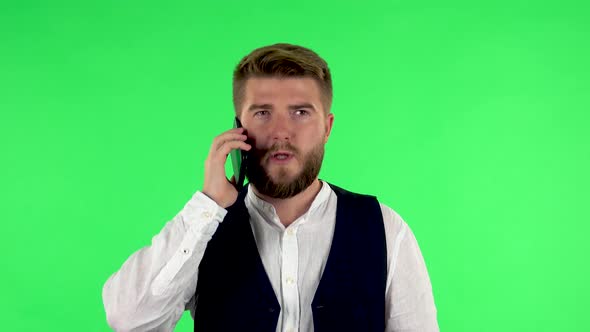 Man Speaking Via Telephone Looking Boredon. Green Screen