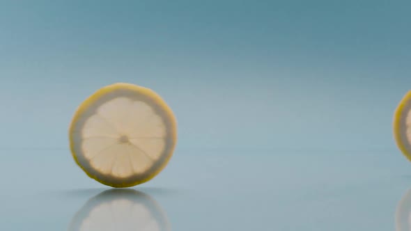 Slow Motion a Lemon Slice Fall on Blue Background Soft Drink with Lemon