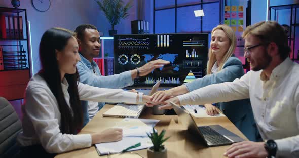 Male and Female Office Workmates which Sitting Behind the Table and Making Unity Symbol