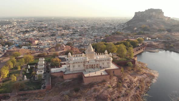 Aerial footage of a historical stone palace before the vast city of Jodhpur, India. 
