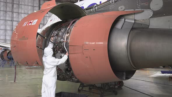 Engineer checks the engine of the aircraft. The repair of aircraft in the hangar