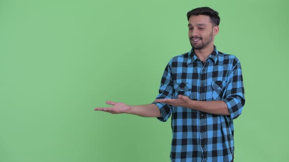 Happy Young Bearded Persian Hipster Man Showing Something