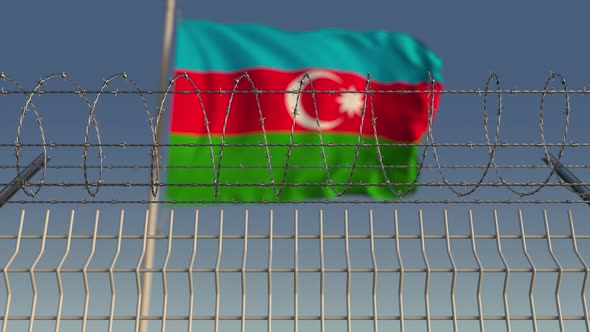 Flying Flag of Azerbaijan Behind Barbed Wire Fence