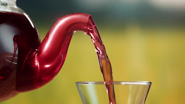 Pouring Red Fruit Tea Into Glass Cup Closeup