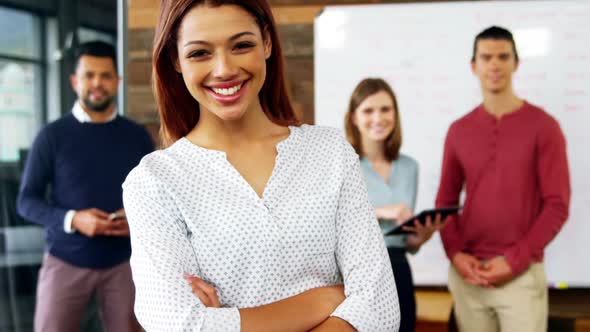 Portrait of happy business woman standing with arms crossed