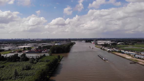 High Aerial View Ship Travelling Along River Noord In Netherlands With Marina In View. Dolly Forward