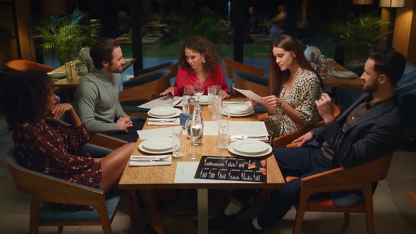 Diverse Friends Talking Together on Fancy Restaurant Meeting at Cozy Evening