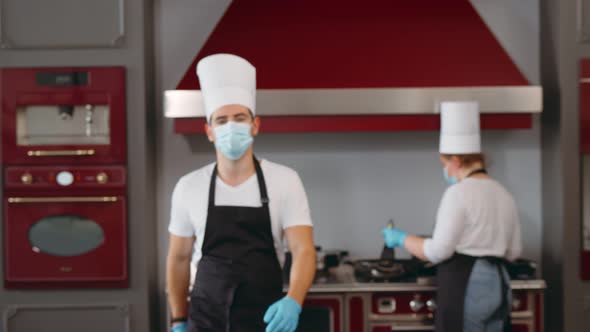 Portrait of Male Chef Wearing Face Protective Medical Mask at Restaurant Kitchen