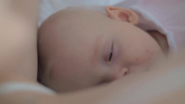 Sleepy Baby Girl Being Breastfed By Her Mother