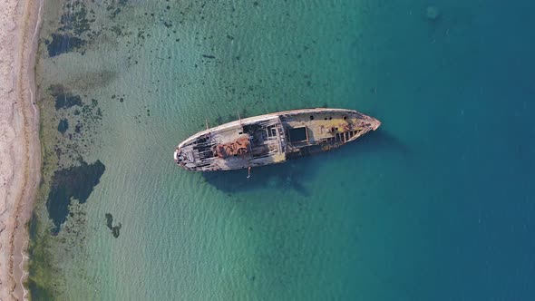 A Wrecked Wooden Ship Lies on the Seashore Covered with Rust