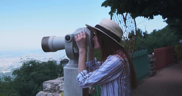 Happy Woman Traveler Looking Through Viewing Binoculars at Tirana City Panorama
