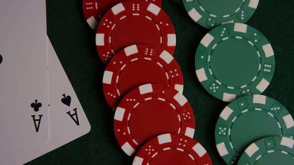 Rotating shot of poker cards and poker chips on a green felt surface - POKER 046