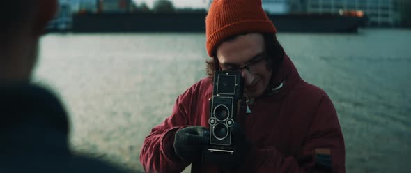 Young man using vintage camera to take pictures of a model