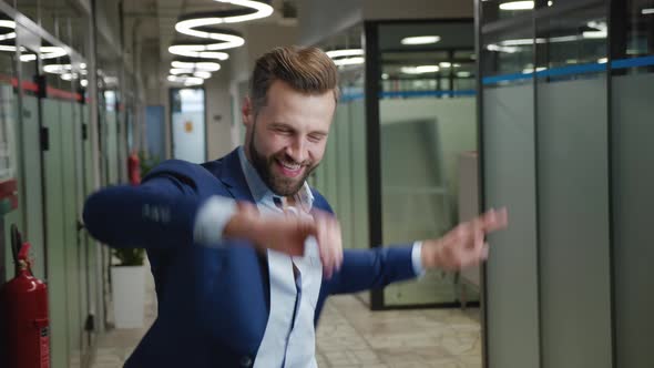 Young Happy Business Manager Wearing Suit Dancing in the Office