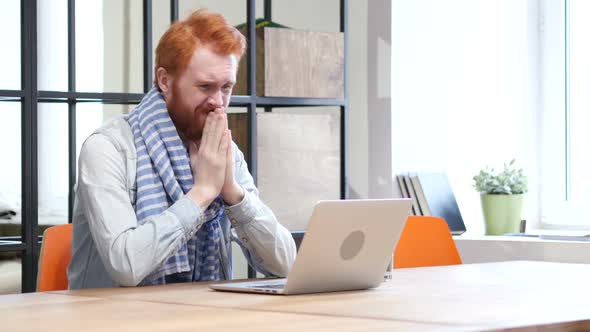 Beard Man Upset by Loss while Working on Laptop