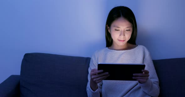 Woman use of tablet computer at night