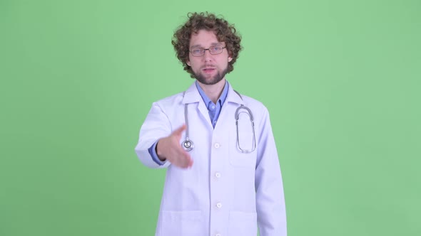 Happy Young Bearded Man Doctor Giving Handshake