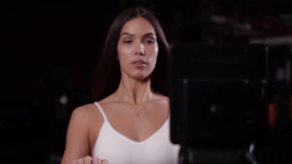 Girl Performs an Exercise for the Muscles of the Hands Sitting on the Simulator