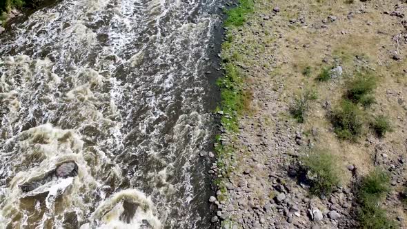 Aerial drone tilting up from a rapid river in a canyon in Mexico