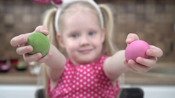 Child Girl Holding Multicolored Chicken Eggs for the Traditional Christian Holiday Easter