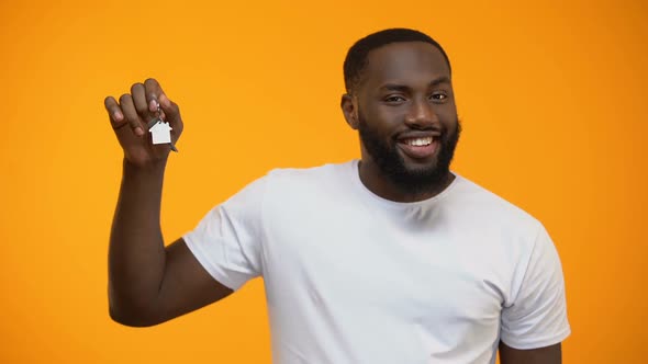 Smiling African-American Man Pointing Finger Into House Keys, Real Estate