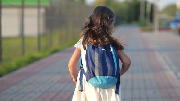 Longhaired Preschooler Girl Runs Skipping to School to Learn