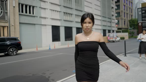 Video of a Fashionable Young Asian Woman in a Black Dress Walking Down a Street