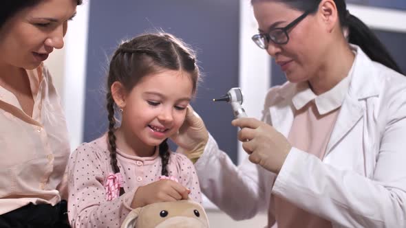 Otolaryngologist Examining Ears of Toy and Child