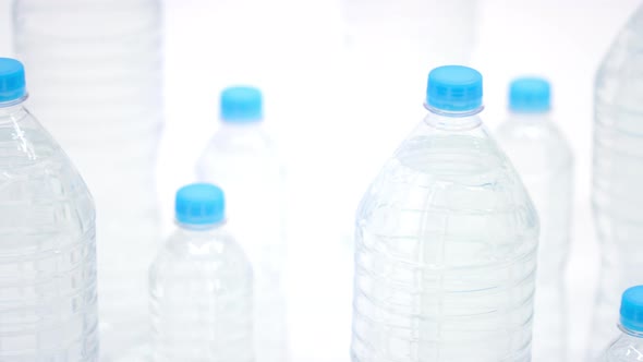 Small and Big Plastic Bottles of Mineral Water with Blue Caps