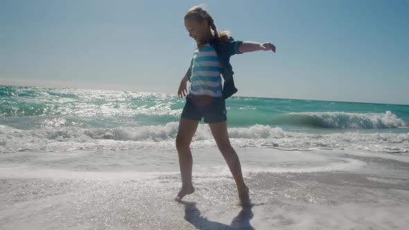 Young girl walking in the water at the beach