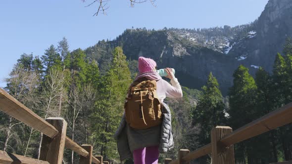 Backpacker Traveler Hiking in Yosemite Back View Woman Walking By Wooden Bridge