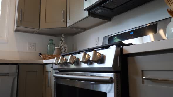 Sliding left shot of a brand new stainless steel chefs range and oven appliance in a newly remodeled