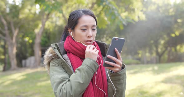Woman taking live stream on cellphone in chinese garden