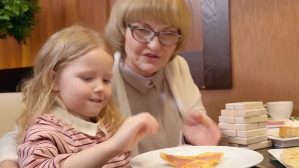 Little Girl Having Pizza at Family Dinner in Cafe