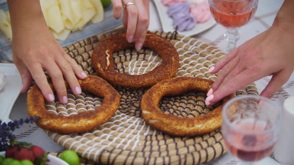 Three Women Take Bagels From the Stand