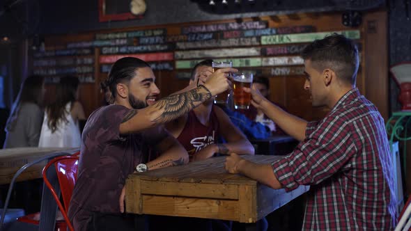 Guys doing chin-chin then drinking beer in a bar in Patagonia Argentina