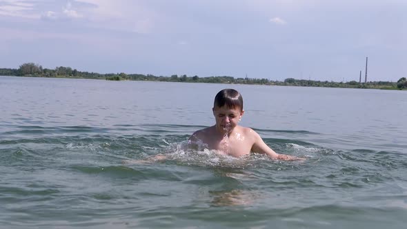 Happy Teenager is Splashing Diving and Having Fun in Ocean Water on the Beach