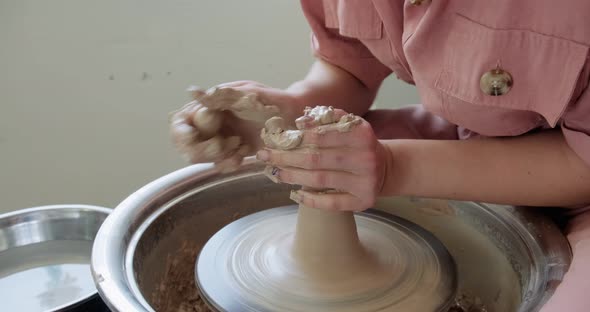 Female Potter Sitting and Makes a Cup on the Pottery Wheel. Woman Making Ceramic Item. Pottery